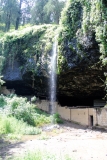 Ein dünner Wasserfall stürzt über die Grotte hinweg.